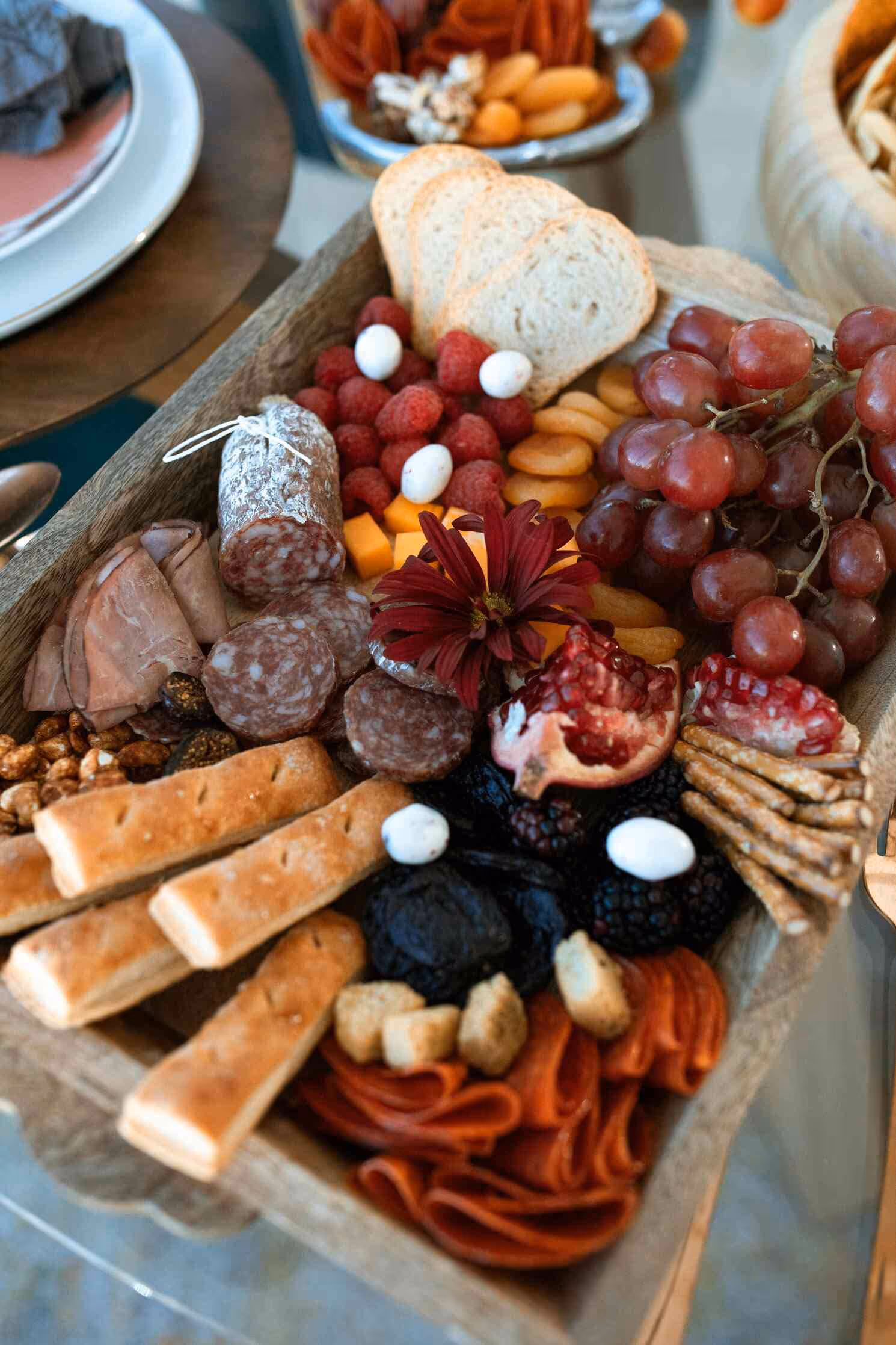 Artful charcuterie and grazing display with fine cheeses, meats, fruits, and seasonal garnishes